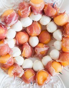 spiedini di mozzarella e palline di melone ricoperte di prosciutto crudo per cene o aperitivi in terrazza