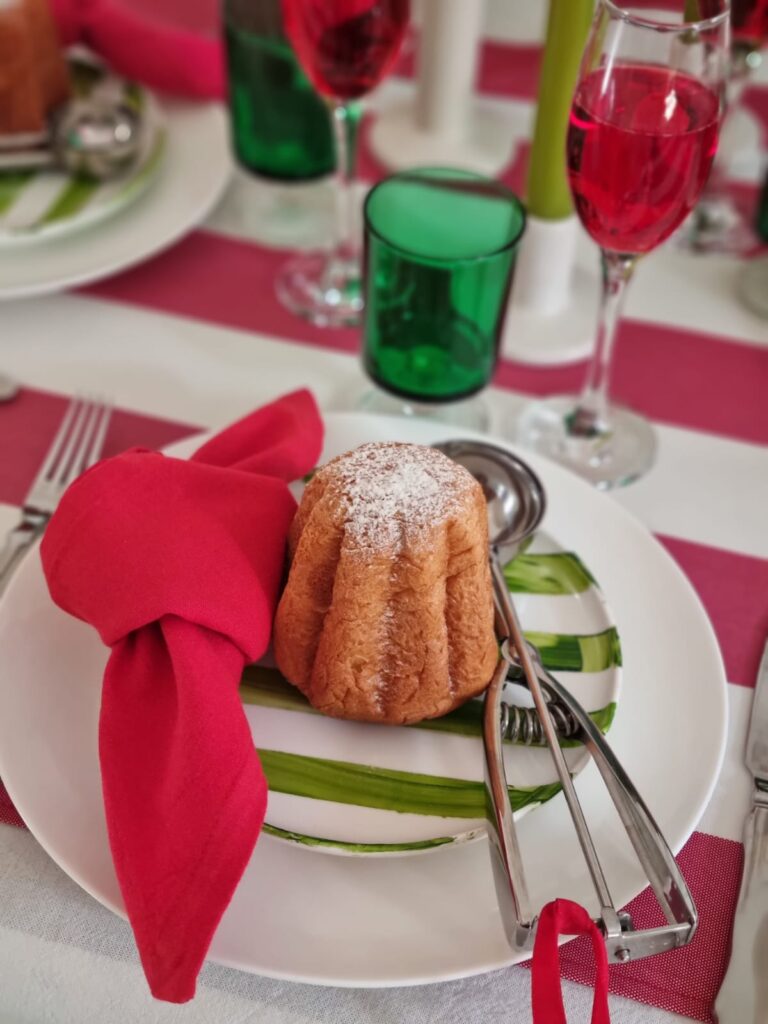 Piatti in ceramica bianchi e a righe verdi con tovagliolo rosso e pandoro mini sul piatto